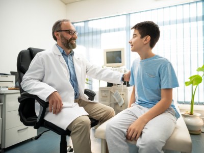 Male doctor talking to adolescent boy