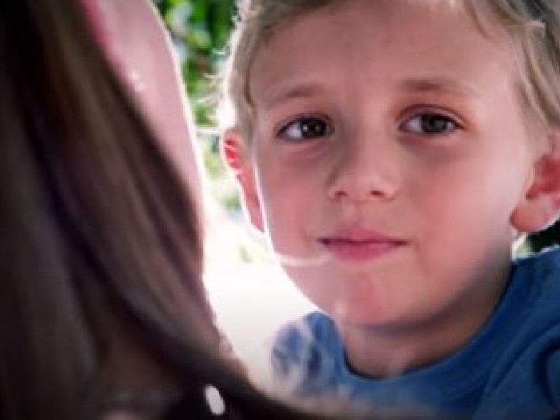 Boy looking over moms shoulder