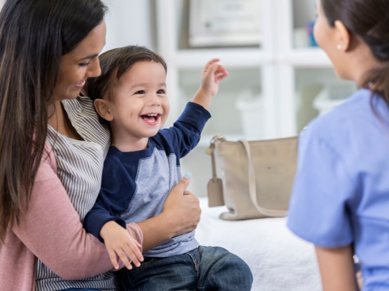 Boy on mother's lap visiting doctor