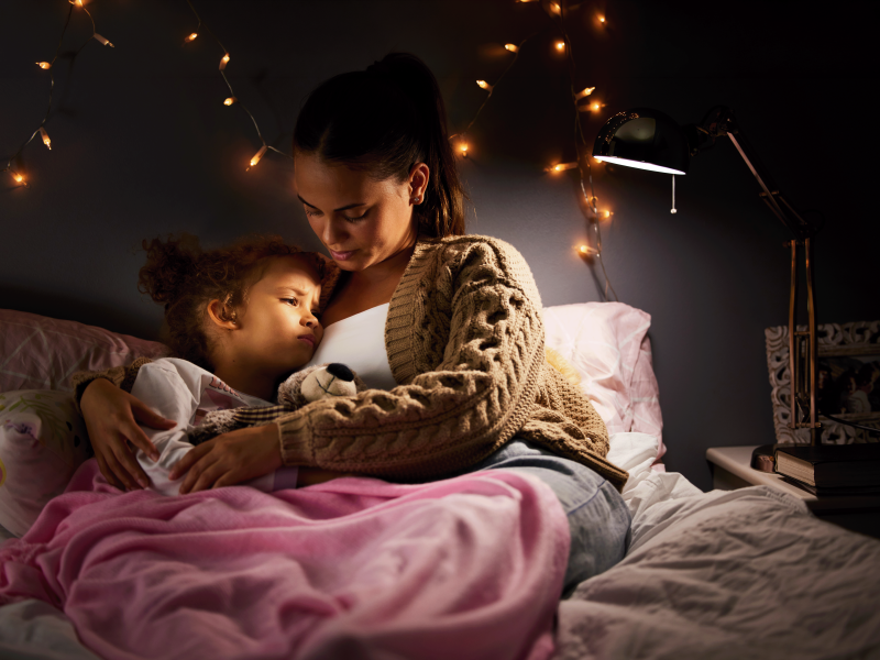 Girl holding sick child at night