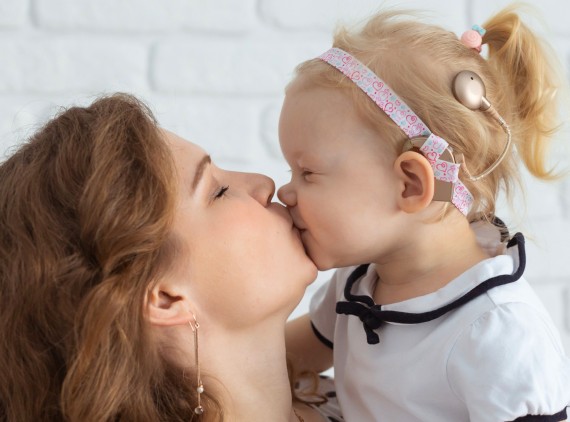 little girl kissing mom