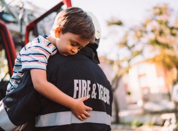 Firefighter holding young boy