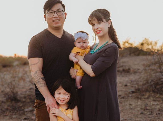 Family photo of mother, father and two young children in desert