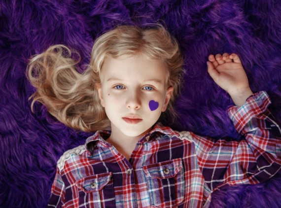 Girl with purple heart sticker on her face