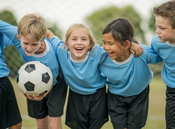 5 young soccer players laughing