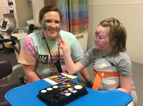 Occupational therapist and child face painting