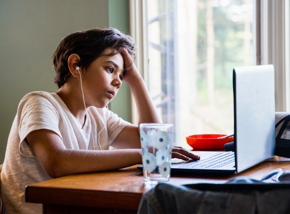 Child studying at home with laptop