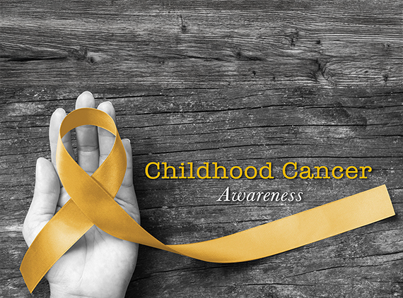 Hand holding gold ribbon representing Childhood Cancer