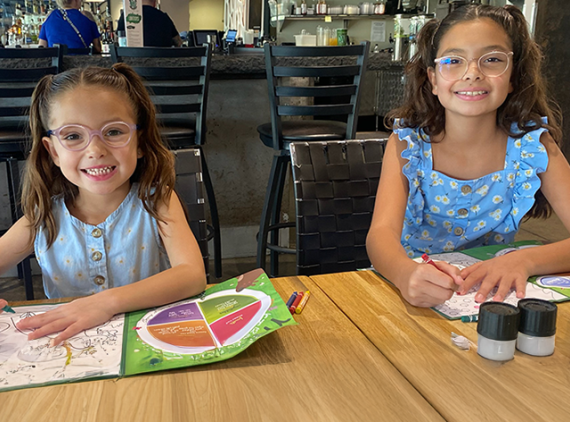 Two girls in glasses, coloring