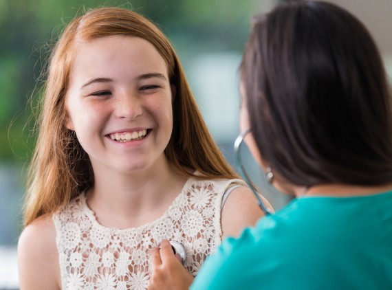 Happy teen talking to her doctor