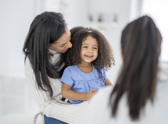 Smiling little girl with parent and provider