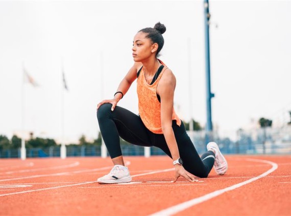 Runner stretching on track