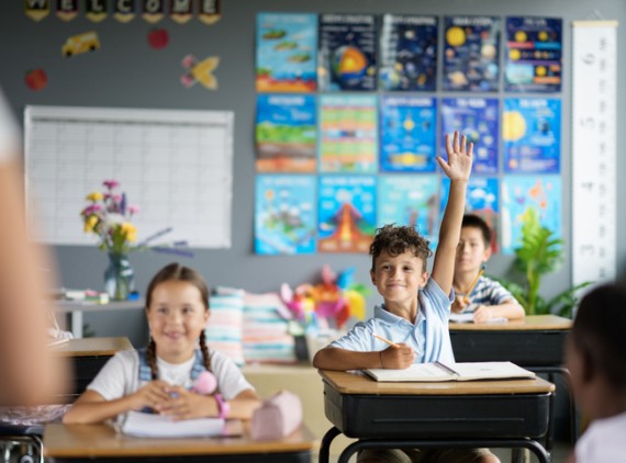 Child raising hand in classroom