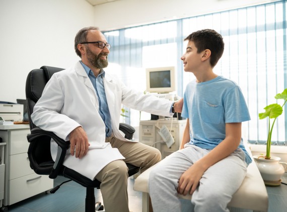 Male doctor talking to adolescent boy