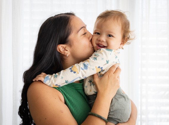 Mother holding & kissing baby