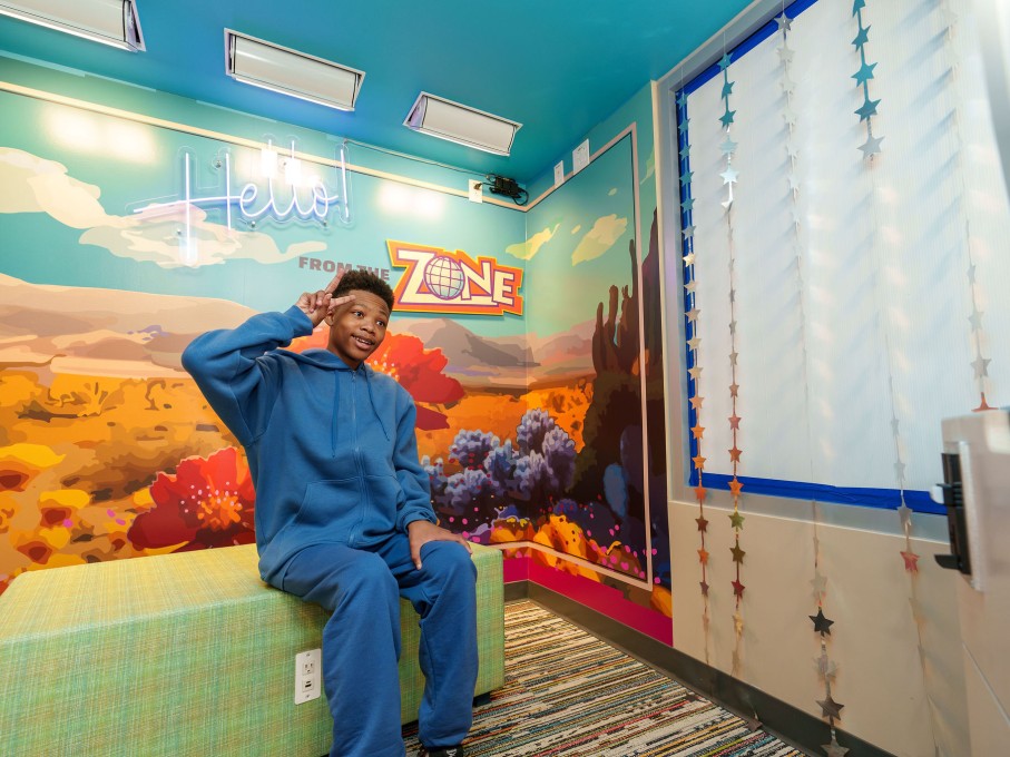 Boy making peace sign in photo booth in The Zone