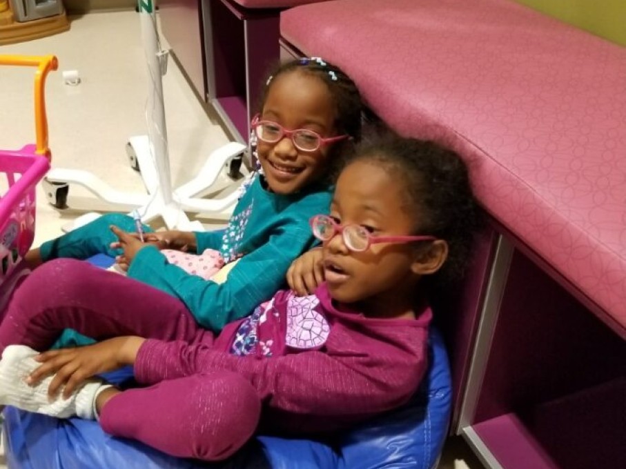 Twin girls sitting on bean bag in exam room