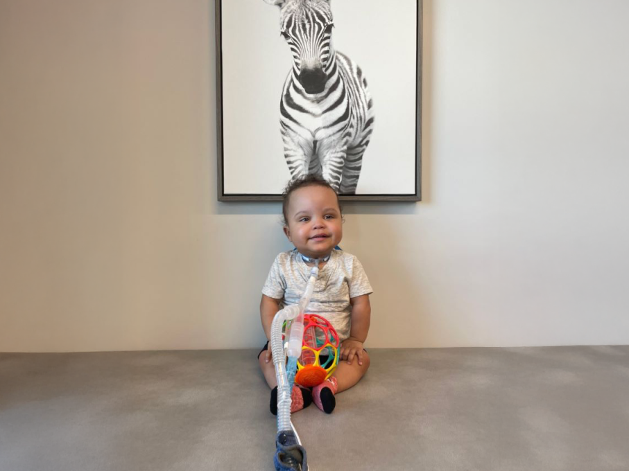 Baby sitting in front of zebra photo