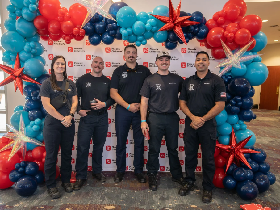 Group of people smiling in front of balloons