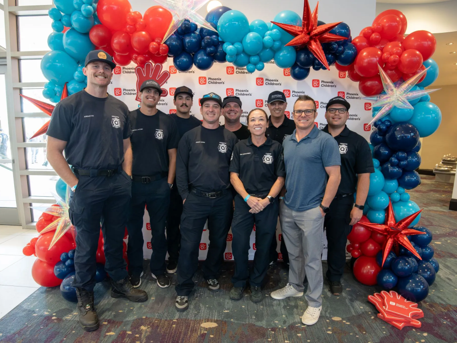 Group of people smiling in front of balloons
