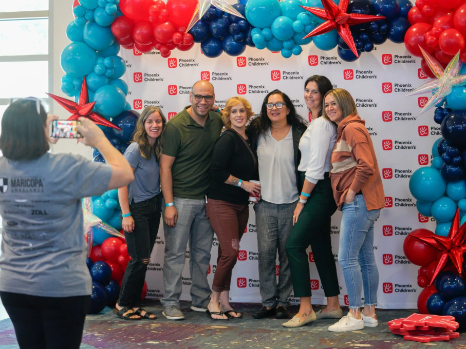 Group of people smiling in front of balloons