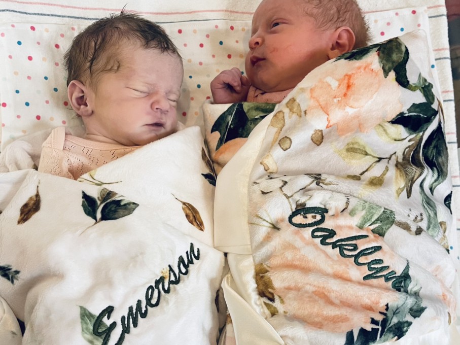 Twin babies wrapped in floral blankets