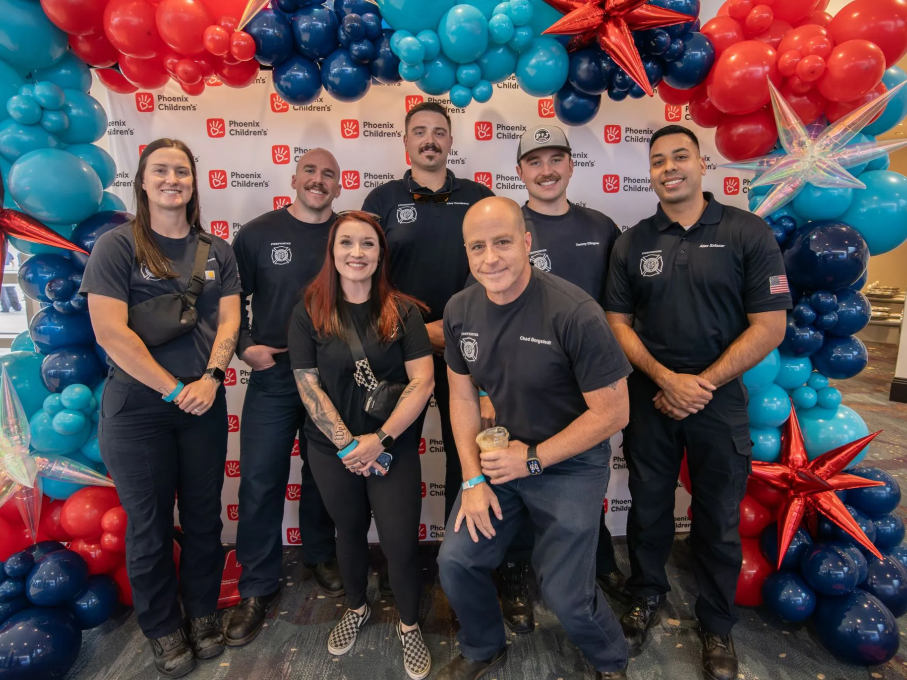 Group of people smiling in front of balloons