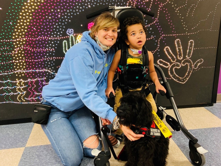 Mother and child posing with support dog