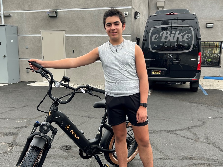 Teen boy standing with bike