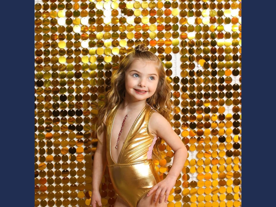 Dancer in gold outfit with gold background