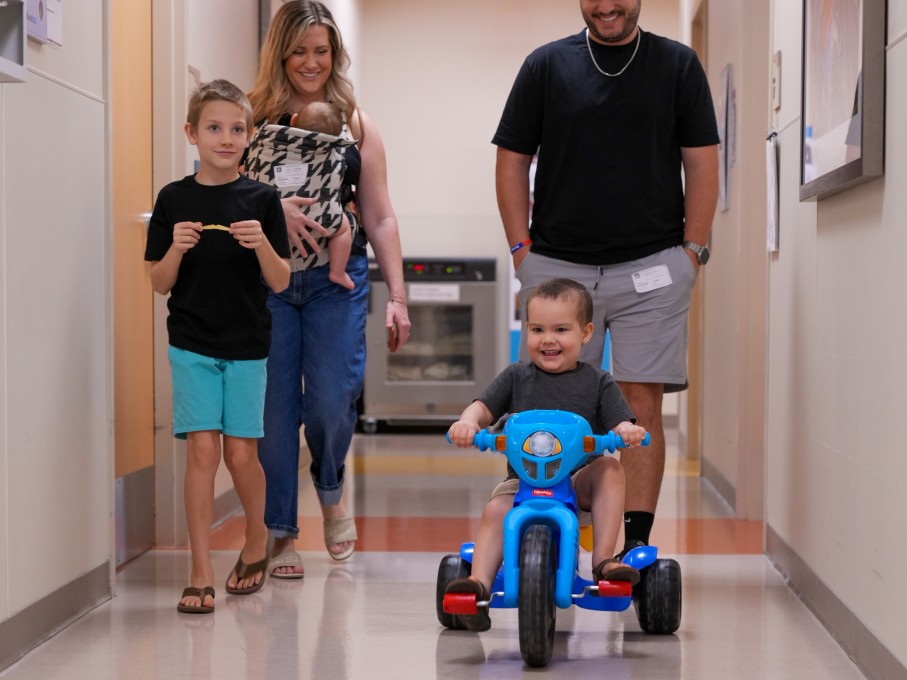 Child riding toy in hospital hall