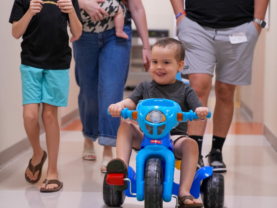 Child riding toy in hospital hall
