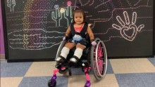 Toddler in pink wheelchair