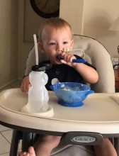 Toddler feeding self in highchair