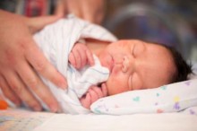 Newborn wrapped in striped blanket