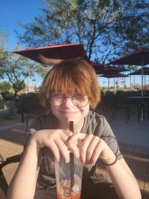 Teen wearing glasses, smiling at camera