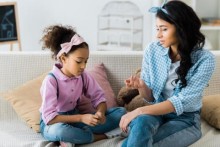 Mother and daughter talking on couch