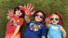 Kids laying in grass showing painted hands