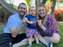 Family of 3 sitting in grass