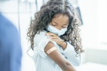 Masked girl with bandage on arm