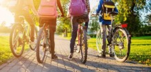 Four kids on bicycles wearing backpacks