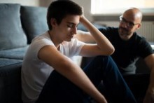 Father and son sitting on floor together