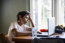 Child studying at home with laptop