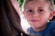 Boy looking over moms shoulder