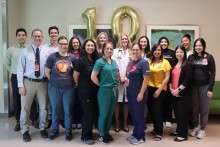 Team of providers in front of number 10 balloon