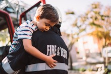 Firefighter holding young boy