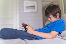 Boy straining his neck while using a tablet