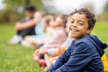 Boy in blue hoodie, smiling at camera