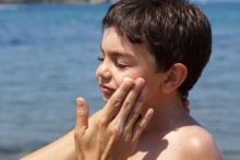 Child getting sunscreen applied to face