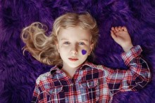 Girl with purple heart sticker on her face